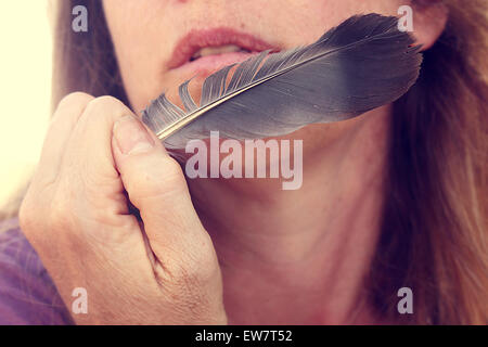 Close up of a Feather près de son visage Banque D'Images