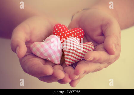 Close up de trois coeurs faits main dans la paume de la Woman's hands Banque D'Images