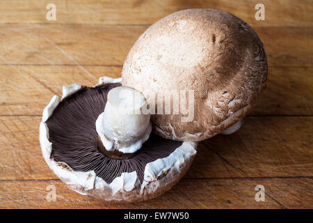 Deux big brown champignon champignons sur planche à découper en bois d'un côté Banque D'Images