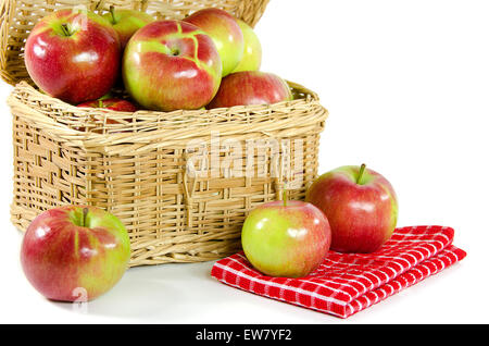 Shiny pommes dans un panier pique-nique en osier isolé sur blanc. Banque D'Images