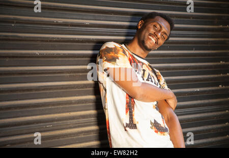 Les jeunes hip African American man posing contre porte de garage Banque D'Images