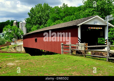 Quarryville, Pennsylvahia : 19e siècle Mount Pleasant Road Covered Bridge avec un Amish farm's silos dans l'arrière-plan Banque D'Images