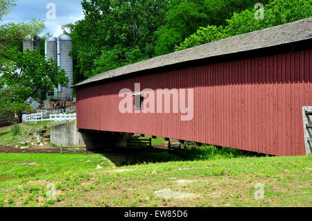 Quarryville, Pennsylvahia : 19e siècle Mount Pleasant Road Covered Bridge avec un Amish farm's silos dans l'arrière-plan Banque D'Images