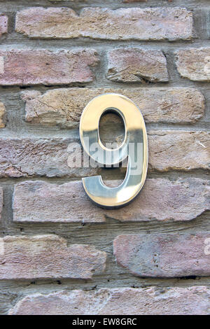 Numéro de maison 9 plaque de zinc sur mur de brique Banque D'Images