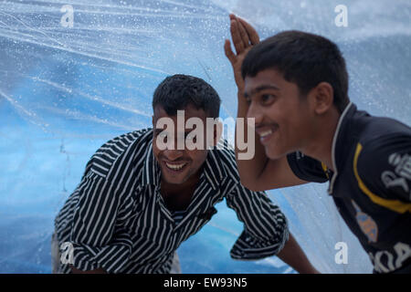 Dhaka, Bangladesh. 20 Juin, 2015. Colporteur couverts leur étal de polyéthylène sous la pluie à Dhaka. Zakir Hossain Chowdhury Crédit : zakir/Alamy Live News Banque D'Images