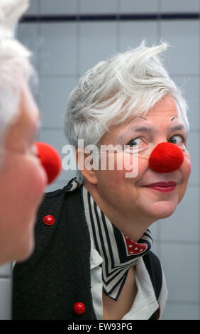 Schwerin, Allemagne. Le 05 juin, 2015. Clown à l'hôpital 'bien' (Ines Vowinkel) regarde dans un miroir car elle se prépare pour une tournée à travers les pupilles de l'infirmière 'Augustenstift' soins infirmiers à Schwerin, Allemagne, 05 juin 2015. Les clowns ont été visiter les malades atteints de démence et les personnes ayant besoin de soins une fois par mois depuis deux ans. Photo : Jens Buettner/dpa/Alamy Live News Banque D'Images