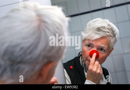 Schwerin, Allemagne. Le 05 juin, 2015. Clown à l'hôpital 'bien' (Ines Vowinkel) regarde dans un miroir car elle se prépare pour une tournée à travers les pupilles de l'infirmière 'Augustenstift' soins infirmiers à Schwerin, Allemagne, 05 juin 2015. Les clowns ont été visiter les malades atteints de démence et les personnes ayant besoin de soins une fois par mois depuis deux ans. Photo : Jens Buettner/dpa/Alamy Live News Banque D'Images