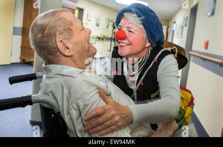 Schwerin, Allemagne. Le 05 juin, 2015. Clown à l'hôpital 'bien' (Ines) Vowinkel embrasse Arno Schadwinkel lors d'une tournée à travers les pupilles de l'infirmière 'Augustenstift' soins infirmiers à Schwerin, Allemagne, 05 juin 2015. Les clowns ont été visiter les malades atteints de démence et les personnes ayant besoin de soins une fois par mois depuis deux ans. Photo : Jens Buettner/dpa/Alamy Live News Banque D'Images