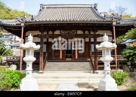 Japon, Onomichi, Temple De Jikoji. Extérieur avant de la salle de bois principale bouddhiste avec deux lanternes en pierre devant. Salle relevée avec des marches menant à lui. Banque D'Images