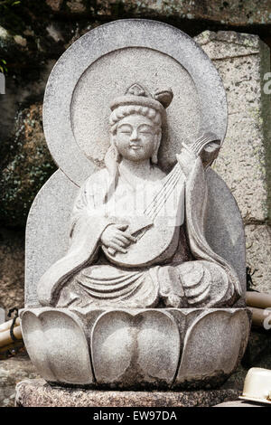 Le Japon, l'Onomichi, Temple Senkoji. Statue en pierre de Bosatsu, Benten, tenant un luth. Elle est la déesse de la musique, les beaux-arts, de l'éloquence et la littérature Banque D'Images