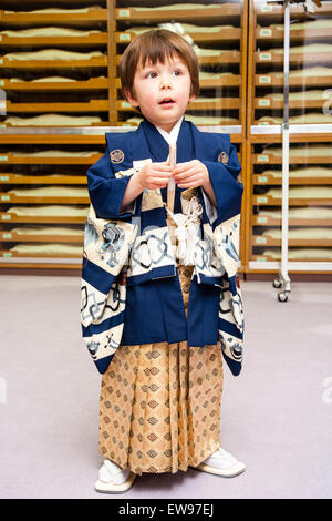 Mixed Race-enfant, garçon, 5 ans, debout à l'intérieur portant des kimono masculins traditionnels japonais complet pour son shichi-go-san cérémonie. Banque D'Images