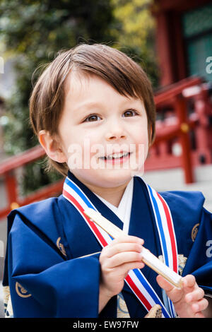 Portrait, 5 ans enfant Asian-Caucasian, garçon, souriant à l'avenir, habillé de son kimono bleu pour shichi-go-san cérémonie au lieu de culte, le Japon. Banque D'Images