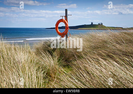 Bouée sur la plage avec Château de Dunstanburgh Embleton Banque D'Images