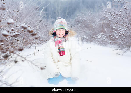 Happy smiling enfant jouant dans un champ de neige Banque D'Images