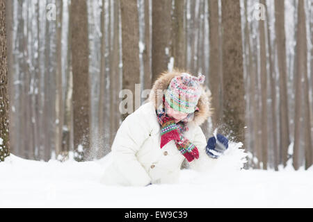 L'enfant drôle de creuser dans la neige Banque D'Images