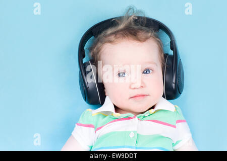 Cute little baby avec d'énormes écouteurs Banque D'Images