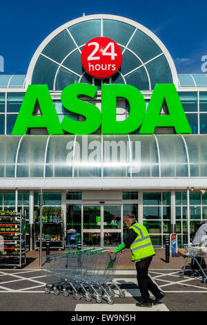 Man Pushing, chariots de supermarché Asda extérieur, Brighton, Sussex, UK Banque D'Images