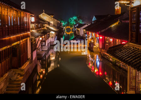 Vue nocturne des maisons chinoises traditionnelles illuminées, télécabine, canal et pont en pierre dans la ville historique de Zhouzhuang, Chine Banque D'Images