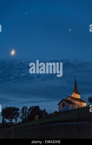 Fechy, Suisse 20 Juin. Une conjonction de Vénus, Jupiter et la Lune dans le ciel du soir sur Fechy église. Dans les nuits suivantes Vénus et Jupiter vont se rapprocher jusqu'à leur concert le 30 juin Crédit : Alistair Scott/Alamy Live News Banque D'Images