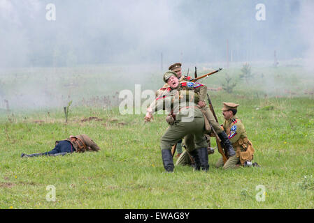 La Russie, CHERNOGOLOVKA - 17 MAI : soldats non identifiés aide un soldat blessé sur l'histoire de la bataille de reconstitution de la guerre civile en 1914-1919 le 17 mai 2014, la Russie Banque D'Images