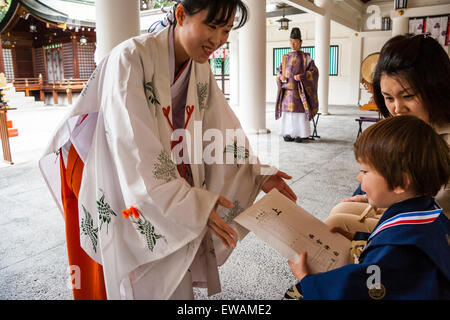 Miko, une jeune fille des sanctuaires japonais, enveloppé jusqu'à enfant, garçon, 5 ans, lors de son passage à l'âge adulte, shichi-go-san cérémonie au lieu de culte Shinto. Banque D'Images