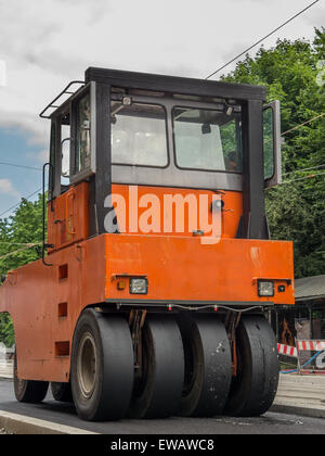 Orange road roller lissant les couche d'asphalte frais Banque D'Images