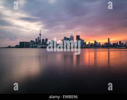 Une vue de la ville de Toronto au coucher du soleil avec des reflets dans l'eau. Prises avec une longue exposition. Banque D'Images