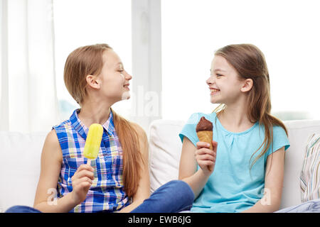 Happy little girls eating ice-cream à la maison Banque D'Images