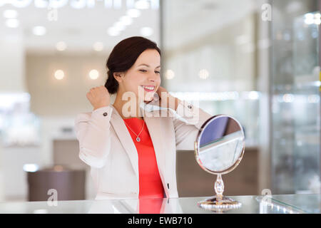 Happy woman choisir au magasin de bijoux pendentif Banque D'Images