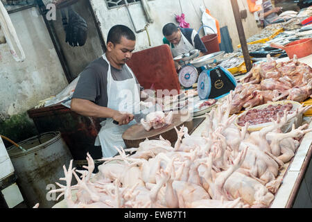 Un boucher prépare un poulet à un étal au marché de nuit de Chow Kit à Kuala Lumpur, Malaisie Banque D'Images