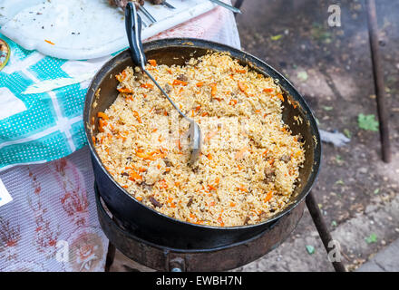 La cuisson pilaf dans un grand chaudron à l'extérieur Banque D'Images