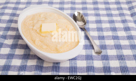 Un bol de gruau de maïs blanc sur un napperon plaid bleu Banque D'Images