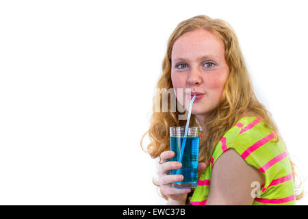 Dutch redhead teenage girl drinking soda bleu avec de la paille isolé sur fond blanc Banque D'Images