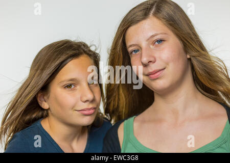 Portrait de deux adolescentes de race blanche avec de longs cheveux soufflé isolé sur fond blanc Banque D'Images