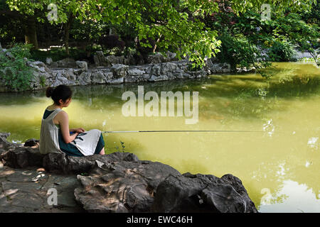 Femme Dame pêche Concession Française Fuxing Park, le quartier de Luwan à Shanghai, Chine Banque D'Images