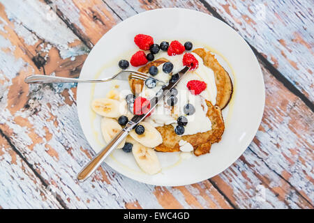 Gluten Free Banana Pancakes & amande avec yogourt sans produits laitiers naturels et les baies fraîches Banque D'Images