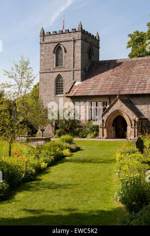 Eglise St Mary, Kettlewell, Yorkshire, Angleterre, Royaume-Uni. Vue depuis le jardin luxuriant, magnifique, avec de l'herbe, chemin meadow fleurs, soleil de l'été et ciel bleu. Banque D'Images