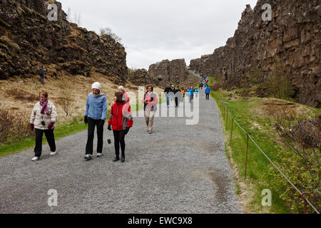 Les touristes à pied à travers la ligne de faille Almannagja dans la dorsale médio-atlantique plaque nord-américaine le parc national de Thingvellir Islande Banque D'Images