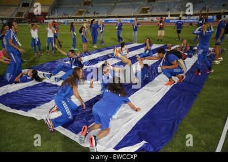 Heraklion, Grèce. 21 Juin, 2015. Les athlètes de l'équipe grec placé deuxième s'asseoir sur un grand drapeau grec hé ont mené au centre du stade. L'équipe de la République tchèque a remporté le championnat européen 2015 de l'équipe de première ligue d'athlétisme en Crète en avance sur la Grèce et les Pays-Bas. Les trois pays ont été promus à la Super League. © Michael Debets/Pacific Press/Alamy Live News Banque D'Images