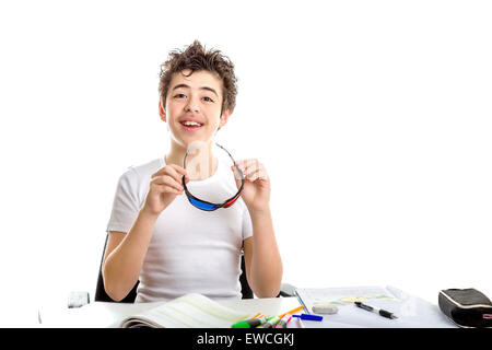 Caucasian boy holding à peau lisse en plastique noir Cinéma 3D lunettes avec les deux mains pendant qu'il fait ses devoirs Banque D'Images