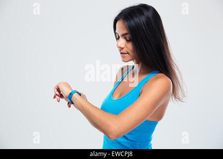 Femme Fitness Fitness tracker à l'aide du poignet sur fond gris Banque D'Images