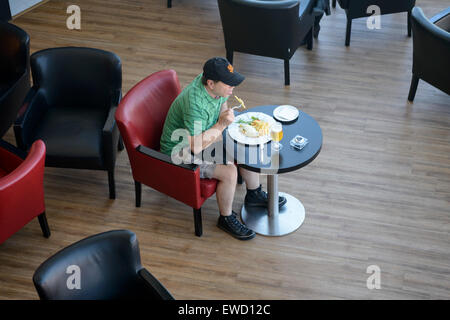 Vue de dessus d'un homme de manger seul dans un restaurant. Banque D'Images