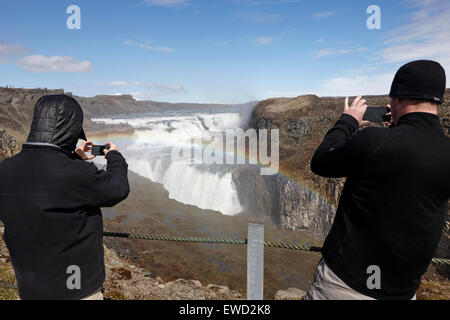 Les touristes de prendre des photos avec les smartphones à la cascade de Gullfoss l'Islande Banque D'Images