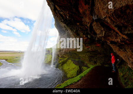 Les touristes sur les allées, derrière la cascade de Seljalandsfoss Islande Banque D'Images