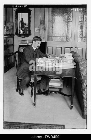 Cette photographie représente un homme non identifié assis à un bureau, peut-être dans un cadre professionnel ou universitaire. La composition met en évidence la simplicité du moment, en se concentrant sur la posture de la figure et l'environnement, bien que le contexte reste inconnu. Banque D'Images