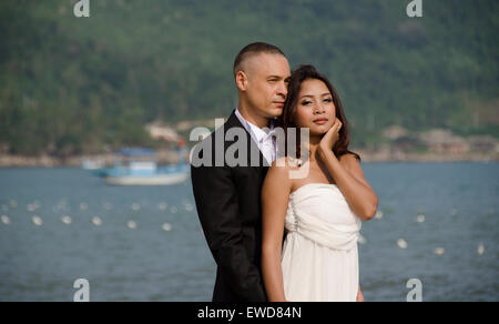 Amoureux couple walking on beach holding hands photo de mariage hugging laughing couple interracial Banque D'Images