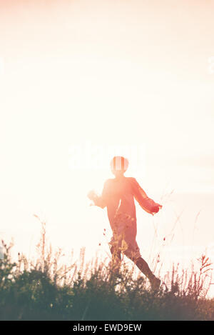 Woman Running à la liberté dans la campagne Champ, Silhouette de femme, double exposition, Vintage Retro ton effet. Banque D'Images