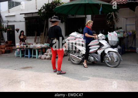 La femme sa moto surchargée après un voyage dans le marché local à Pattaya en Thaïlande Banque D'Images