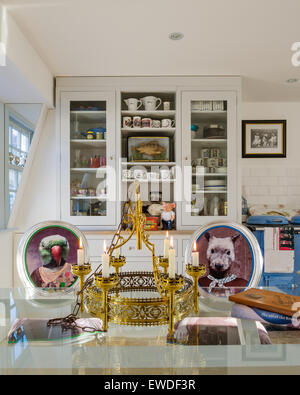 Chaise de salle à manger Meubles dans Visitorian Cory imprime autour d'une table à manger en verre surmontée cuisine avec vaisselier blanc et aga Banque D'Images