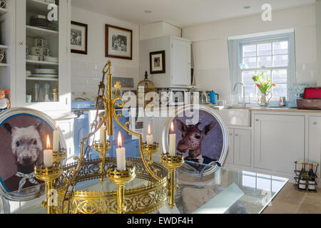 Chaise de salle à manger Meubles dans Visitorian Cory imprime autour d'une table à manger en verre surmontée cuisine avec vaisselier blanc et aga Banque D'Images